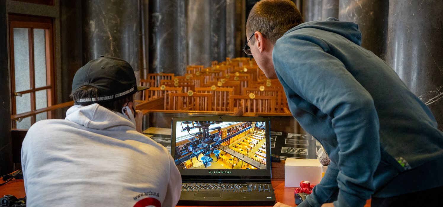 Arctur employees looking at the top down view of the library on their laptop.