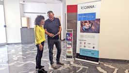 Photo of a woman and two boys looking at Reginna 4.0 fliers. In front of them is an interactive display screen.