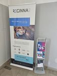 Photo of a woman and two boys looking at Reginna 4.0 fliers. In front of them is an interactive display screen.