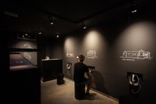 A man sitting in a dark room wearing VR goggles and viewing Rajhenburg Castle.