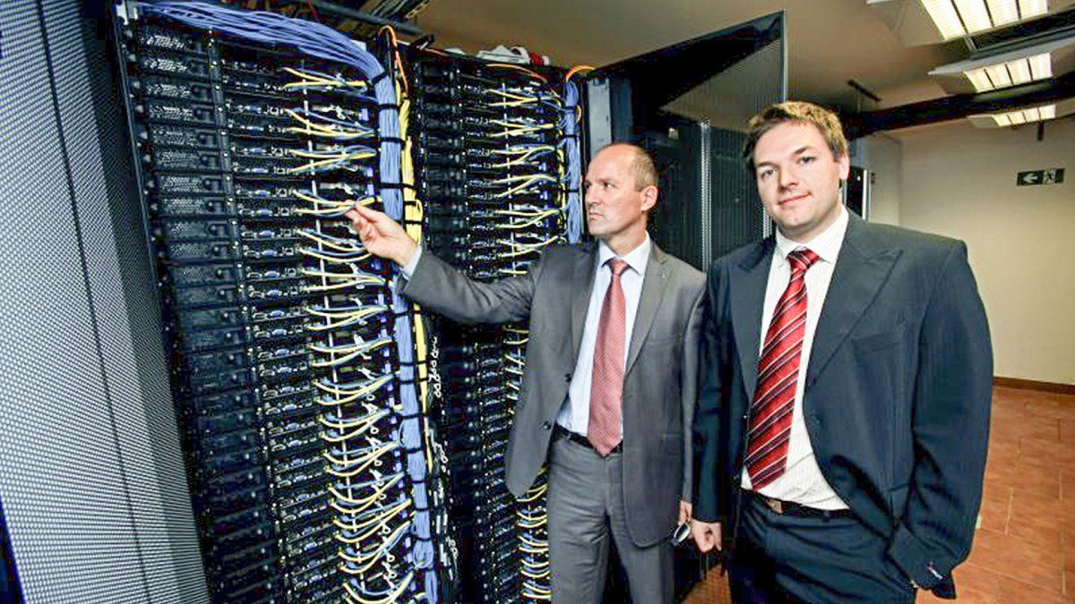 Photograph of Arctur CEO & Founder and and Arctur employee next to Arcturus first supercomputer.