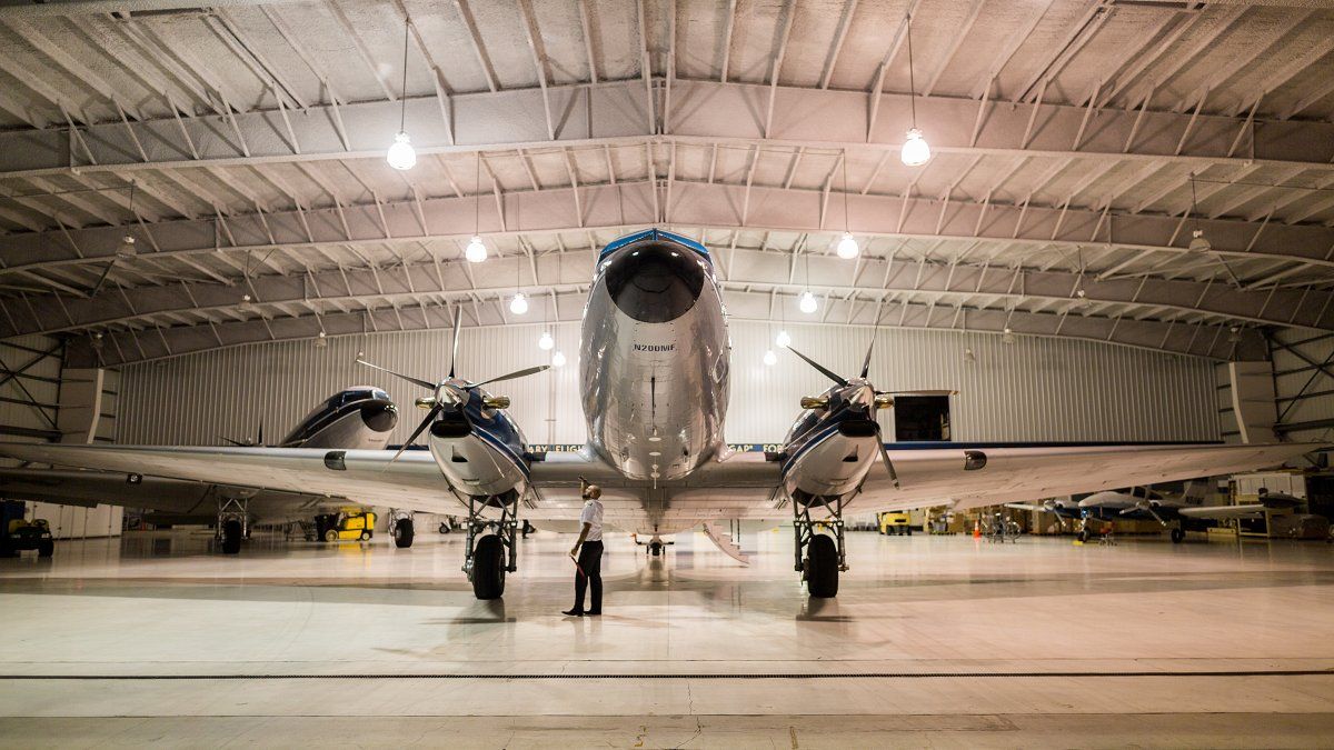 Front view photograph of a modify Douglas DC-3 airplane parked in a hanger.
