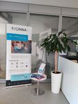 Photo of a woman and two boys looking at Reginna 4.0 fliers. In front of them is an interactive display screen.