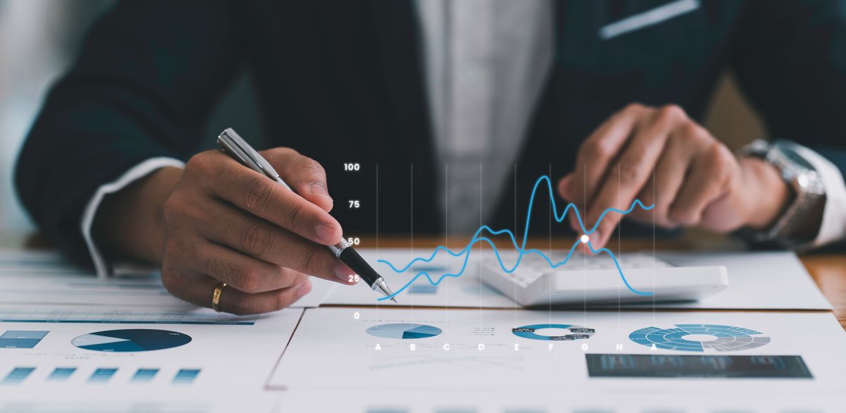 a businessman analyzing data on the table, hologram of data graph in front of him