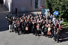 A group photograph from a seminar in front of a pink building.