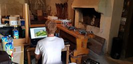 A photograph of an Arctur employee mapping a 3D terrain. Next to him are three different drones.