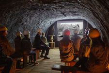 A group of tourists watching an animated video about the lakes and underground mines.