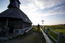 A drone operator flying his drone on Velika Planina.