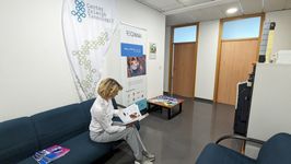 Photo of a woman and two boys looking at Reginna 4.0 fliers. In front of them is an interactive display screen.