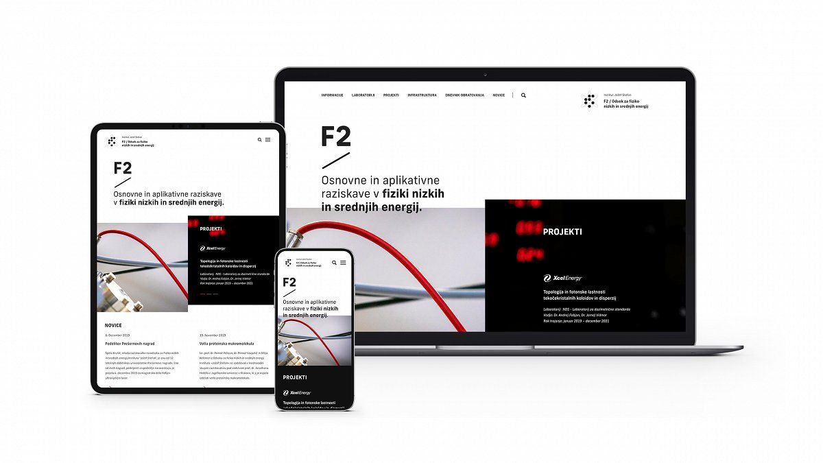 A photograph of a laptop, mobile phone, and tablet displaying the homepage of the F2 - Low and Medium Energy Physics department.