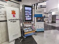 Photo of a woman and two boys looking at Reginna 4.0 fliers. In front of them is an interactive display screen.
