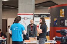 Three Arctur employees talking with a visitor at their stand at the EES Tech Challenge.