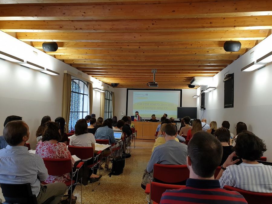 Photograph of an presentation of DIVA project. Three presenters are gibing a presentation to a audience.