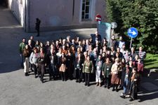 A group photograph from a seminar in front of a pink building.